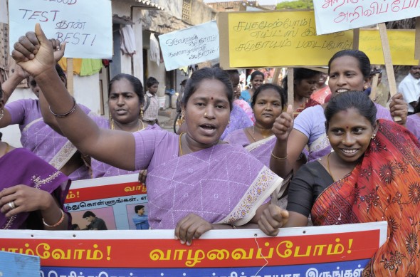 Women in the Rangoon Street neighborhood of Chennai, India, march through the narrow streets near their homes to help educate their neighbors about HIV and AIDS.